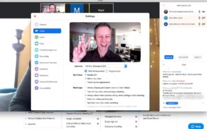 Man smiling and waving in on online video conference window